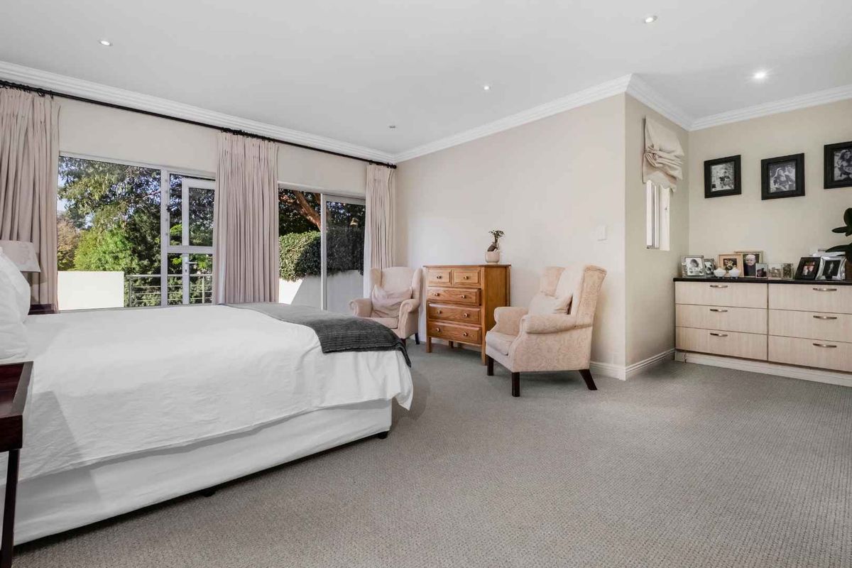 Spacious bedroom featuring neutral carpeting, recessed lighting, crown molding, and large sliding glass doors providing access to an outdoor area.