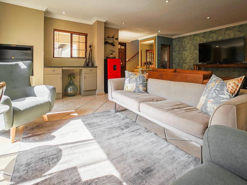 Spacious living room featuring tiled flooring, recessed downlighting, and built-in cabinetry, creating a comfortable and functional open-plan living space.