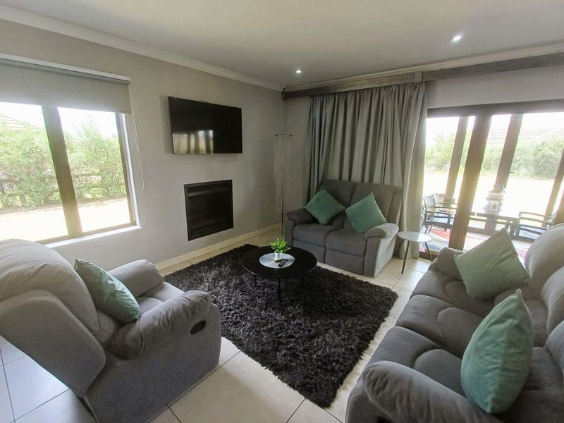 A well-maintained living room featuring tiled floors, a built-in fireplace, and large sliding glass doors providing access to the outdoor area.