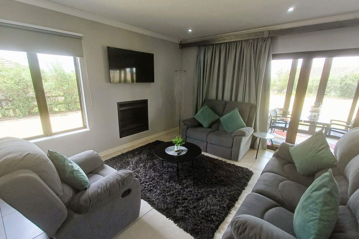 A well-maintained living room featuring tiled floors, a built-in fireplace, and large sliding glass doors providing access to the outdoor area.