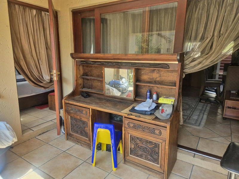 A covered patio area featuring tiled flooring and access to the interior through a sliding glass door and wooden door frame.