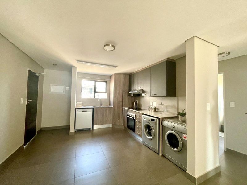 Modern kitchen featuring built-in cabinetry, integrated appliances, tiled flooring, and a functional layout with ample counter space.