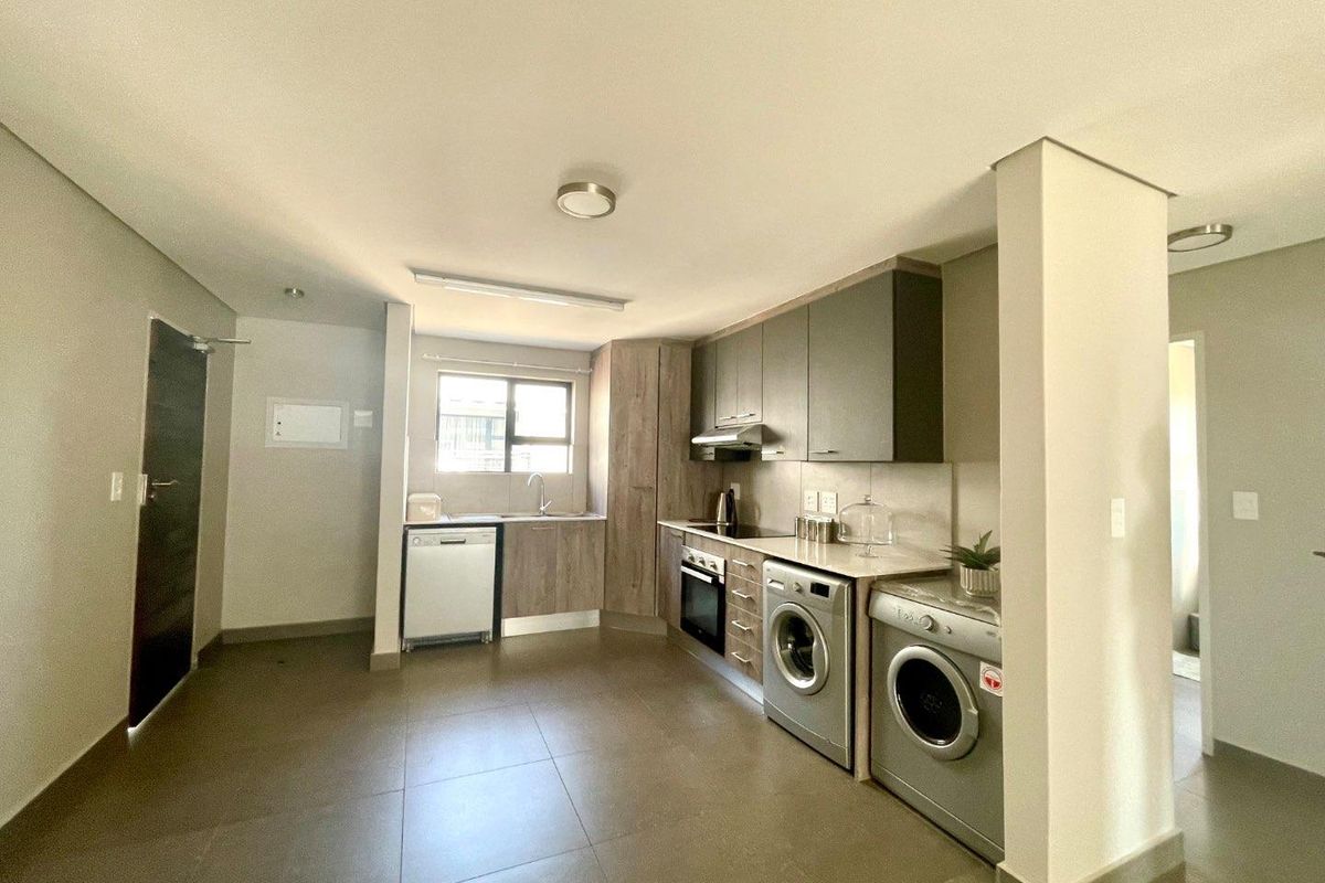 Modern kitchen featuring built-in cabinetry, integrated appliances, tiled flooring, and a functional layout with ample counter space.