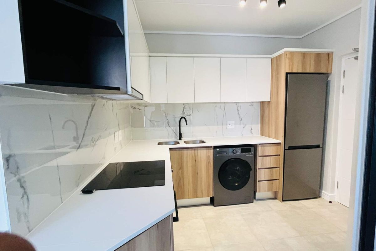 Modern kitchen featuring sleek white and wood-grain cabinetry, marble-look splashback, integrated appliances, and high-quality finishes throughout.