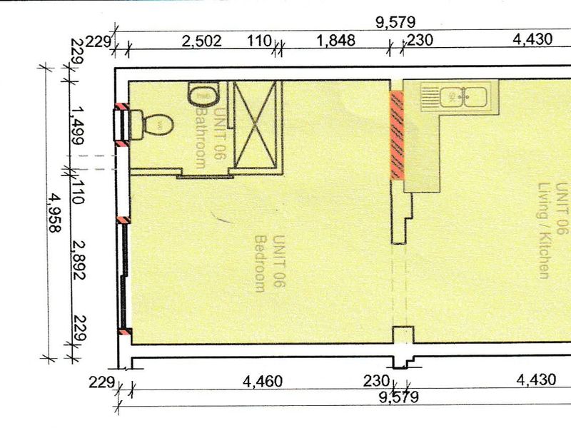 Architectural floor plan for Unit 06, showing the layout of the bedroom, bathroom, and open-plan living and kitchen area.