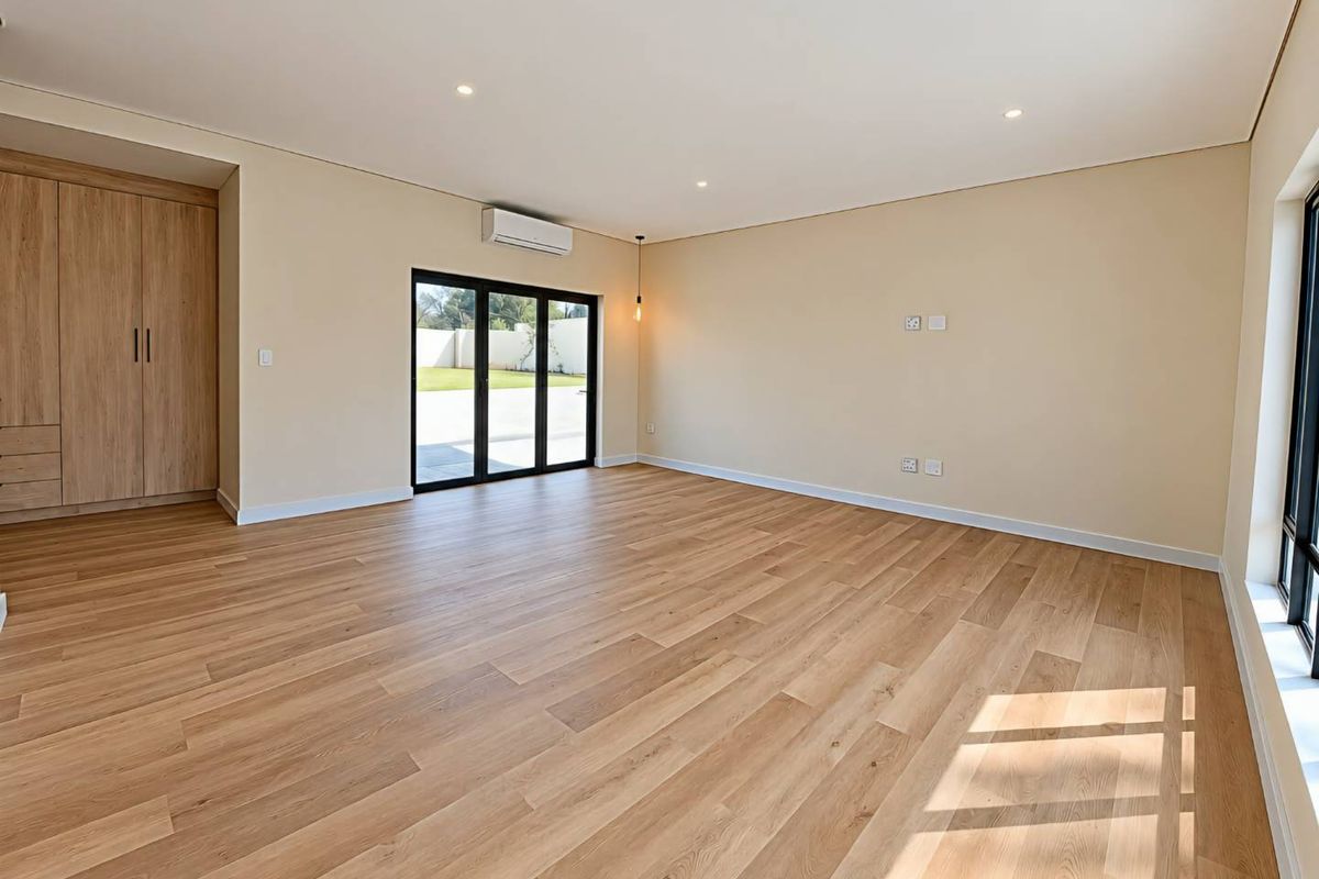 A bright, modern, and spacious living area featuring light timber flooring, built-in storage cabinetry, and large sliding doors leading to the outdoor space.