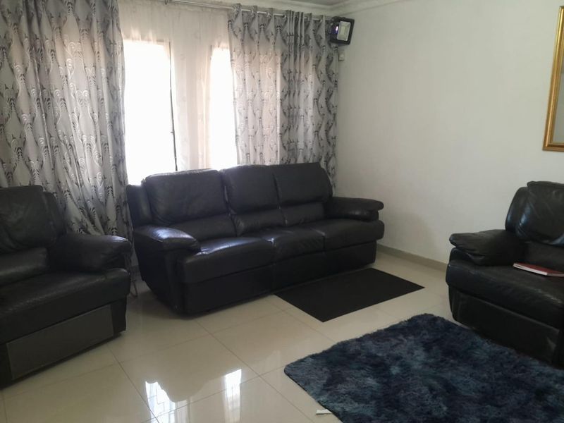 A living room featuring tiled flooring and decorative ceiling cornicing, providing a neutral base for interior design updates.