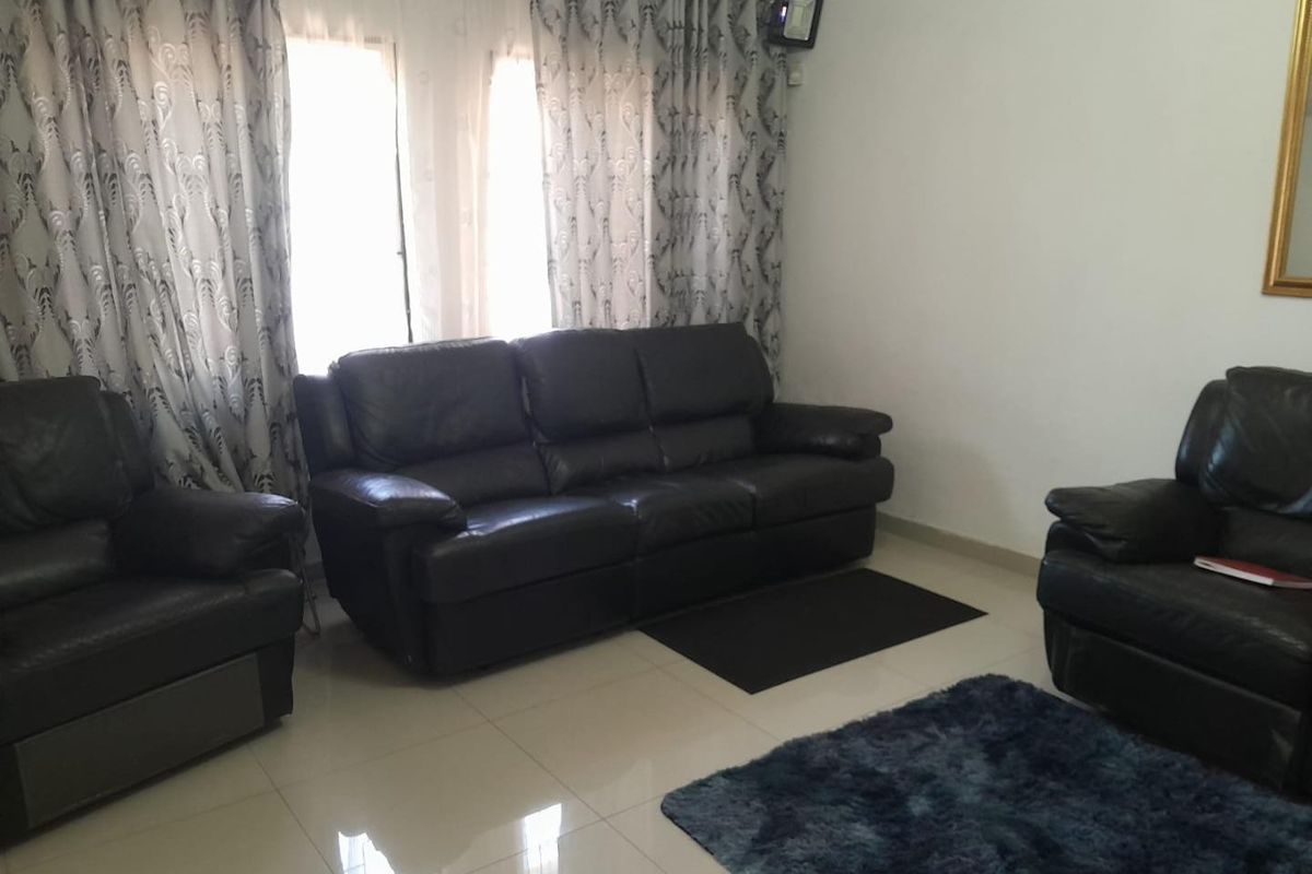 A living room featuring tiled flooring and decorative ceiling cornicing, providing a neutral base for interior design updates.