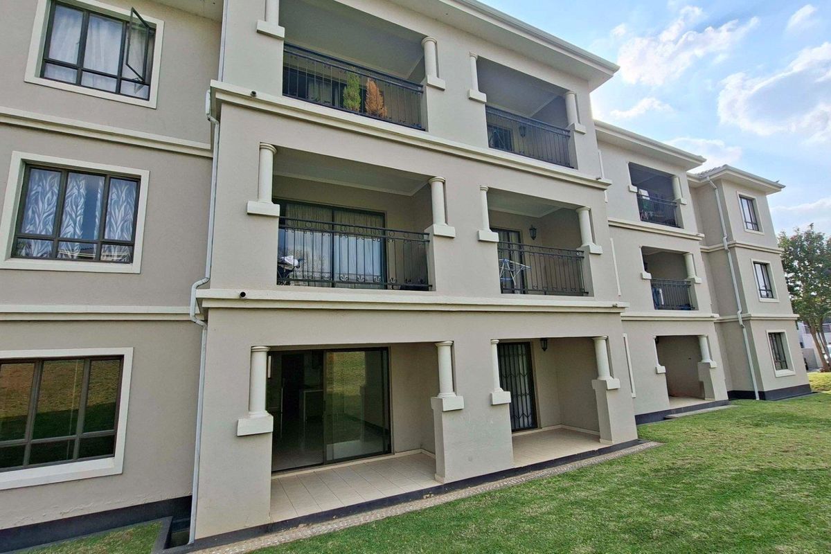 Exterior view of a multi-story apartment building featuring private balconies with metal railings and sliding glass doors on each level.