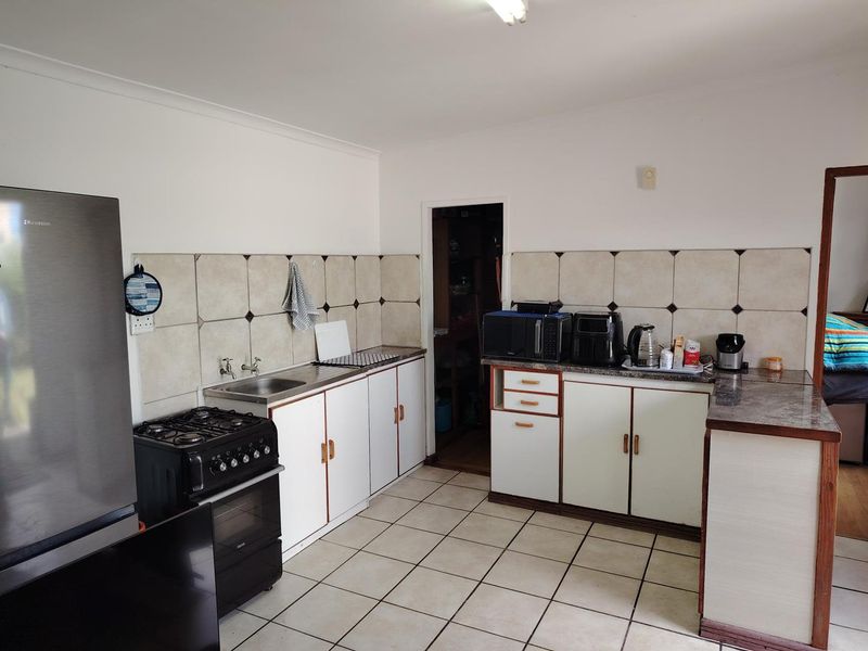 Functional kitchen featuring tiled backsplash, laminate countertops, built-in cabinetry, and a gas stove with oven, providing a practical workspace for daily cooking.