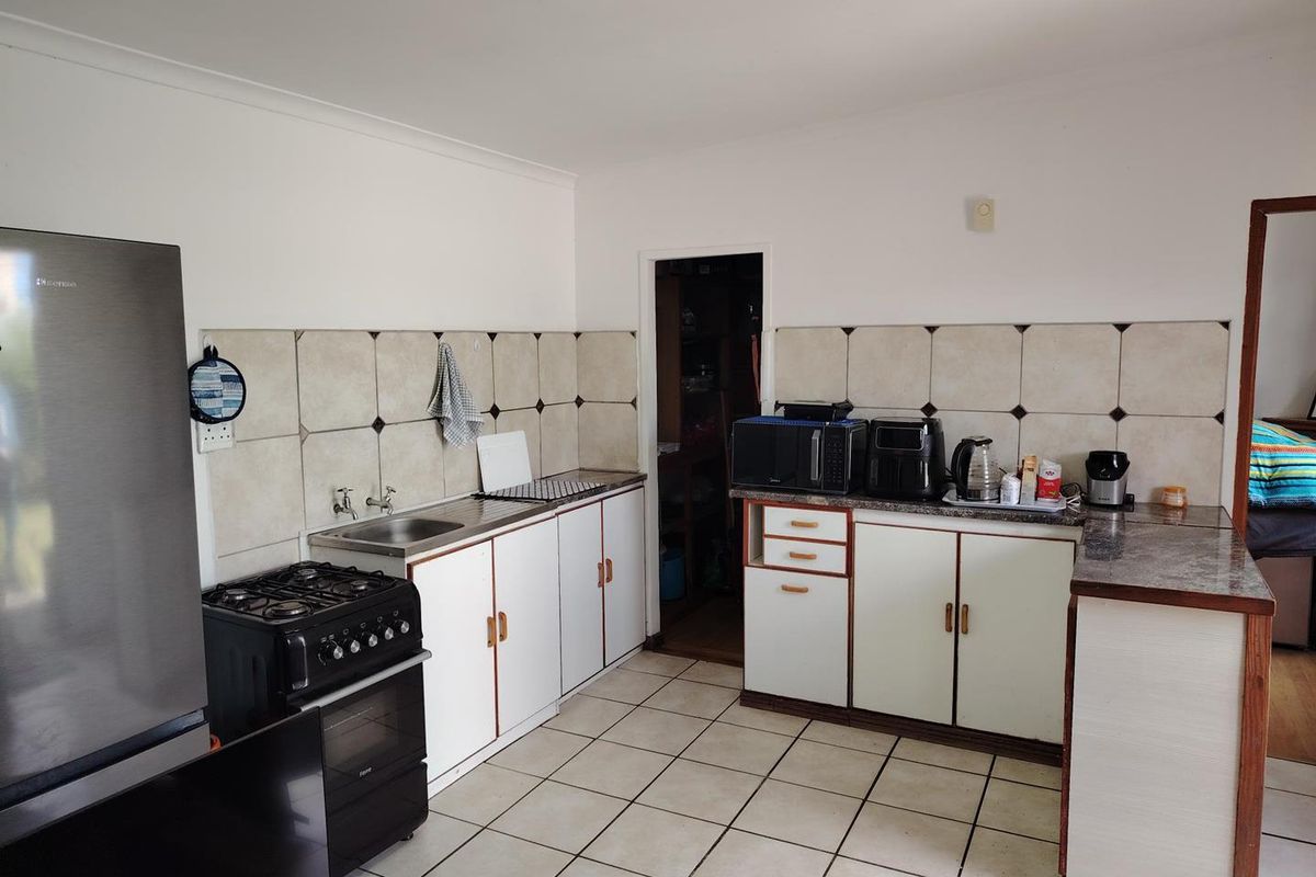 Functional kitchen featuring tiled backsplash, laminate countertops, built-in cabinetry, and a gas stove with oven, providing a practical workspace for daily cooking.