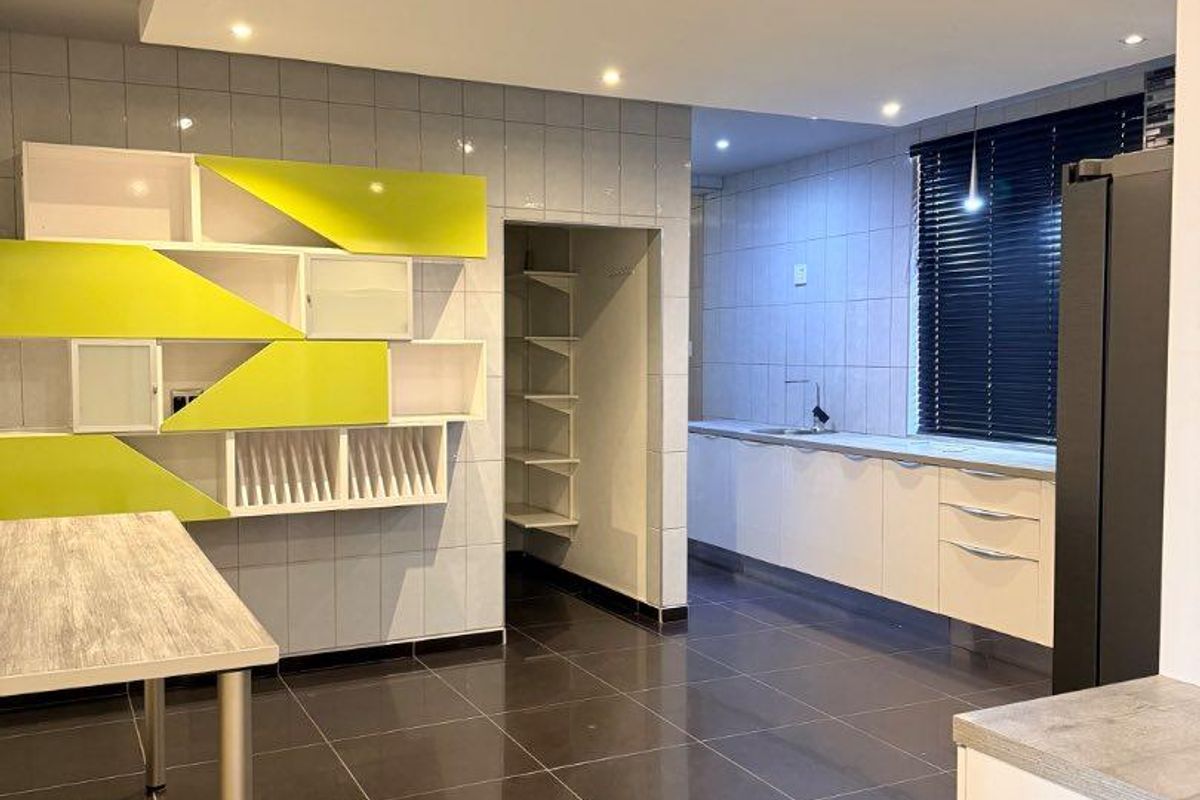 Modern kitchen featuring high-gloss cabinetry, tiled flooring, recessed ceiling lighting, and a dedicated walk-in pantry area.