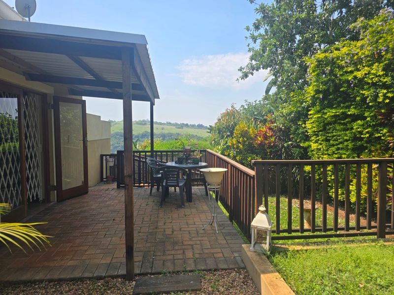 A covered brick-paved patio featuring a timber balustrade and scenic views, providing an ideal outdoor space for relaxation and entertaining.