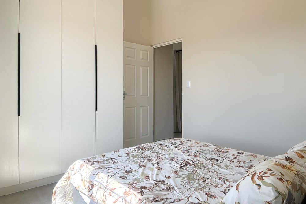 Spacious second bedroom with built-in cupboards.