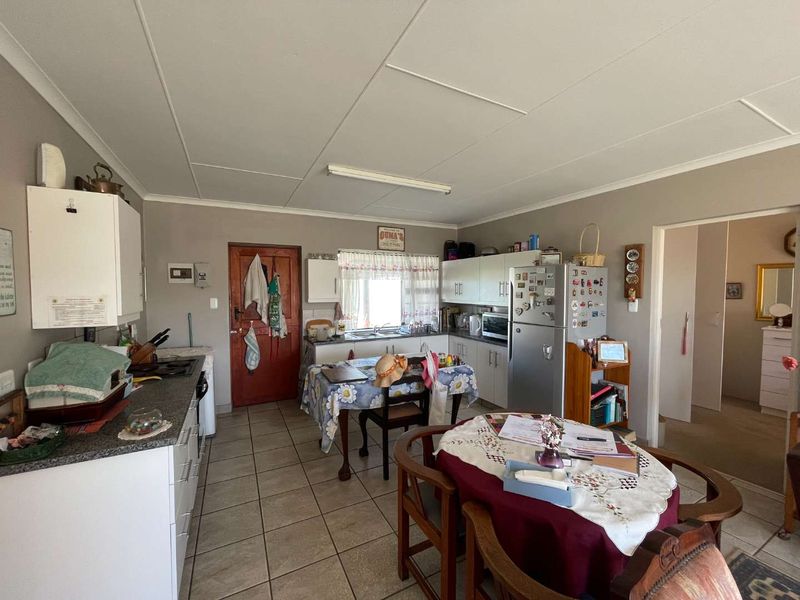 A functional kitchen featuring built-in cabinetry, laminate countertops, a double basin sink, and tiled flooring, offering a practical layout for daily meal preparation.