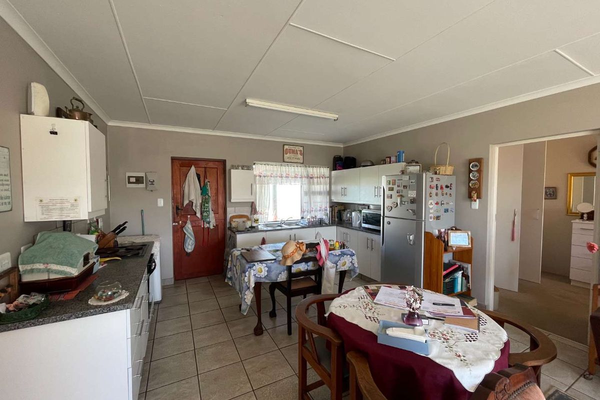 A functional kitchen featuring built-in cabinetry, laminate countertops, a double basin sink, and tiled flooring, offering a practical layout for daily meal preparation.
