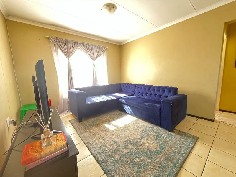 A living room featuring tiled flooring and neutral wall finishes, providing a functional space for relaxation.