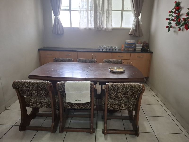 A dining room featuring tiled flooring and built-in cabinetry providing additional storage space.