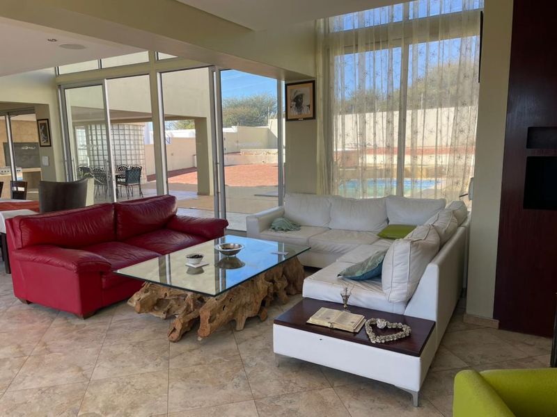 Spacious living room featuring large sliding glass doors that provide seamless indoor-outdoor flow to the patio and pool area.