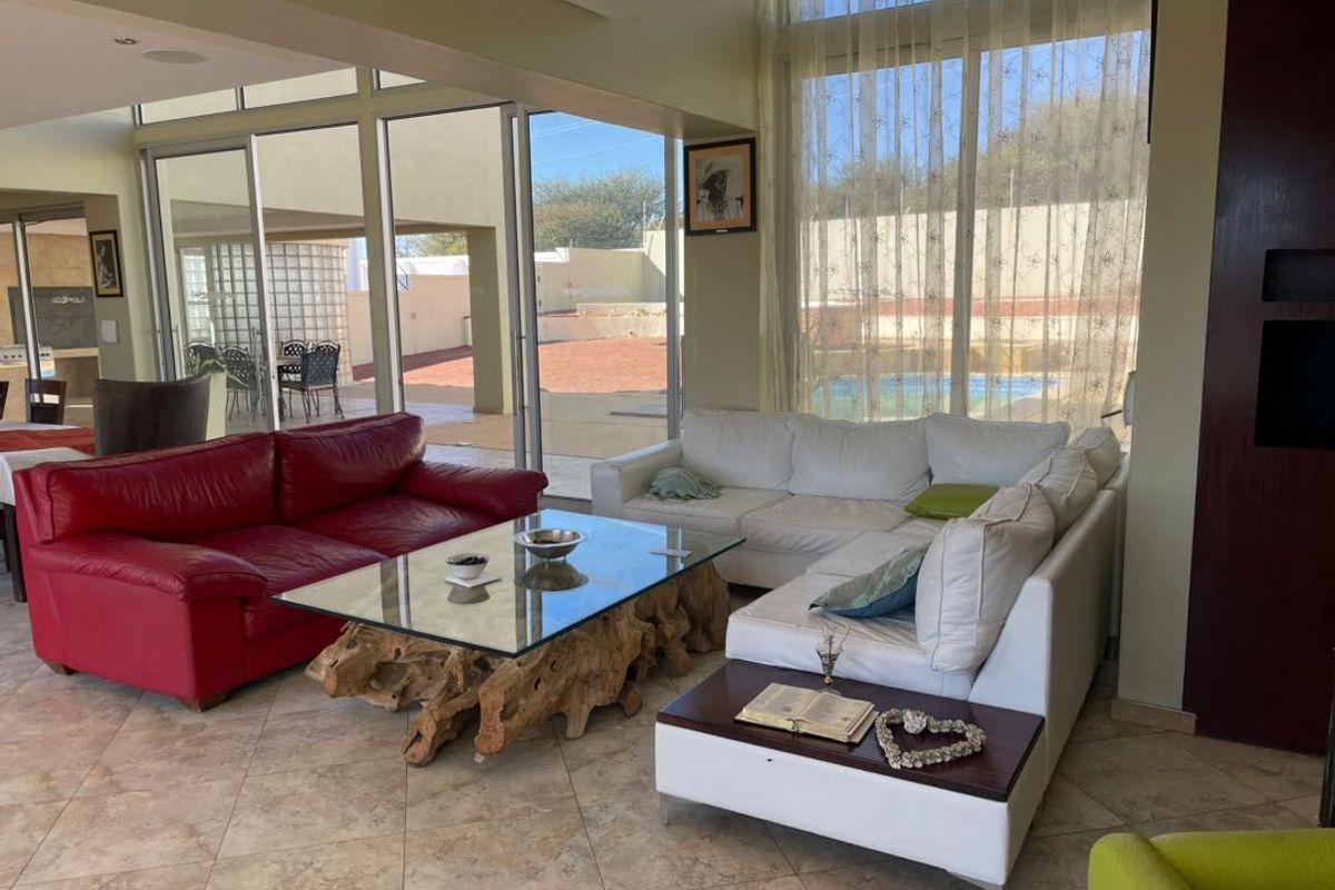 Spacious living room featuring large sliding glass doors that provide seamless indoor-outdoor flow to the patio and pool area.