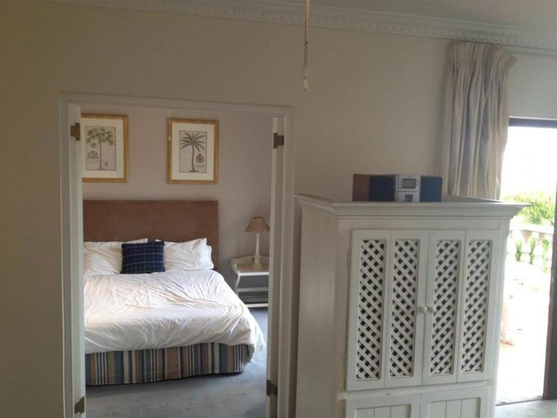 A bedroom view featuring crown molding and a double door entrance leading to an adjacent space with balcony access.