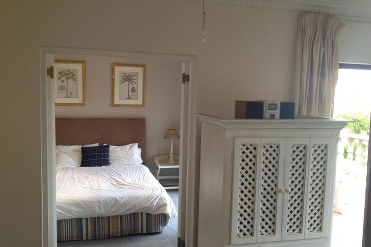A bedroom view featuring crown molding and a double door entrance leading to an adjacent space with balcony access.