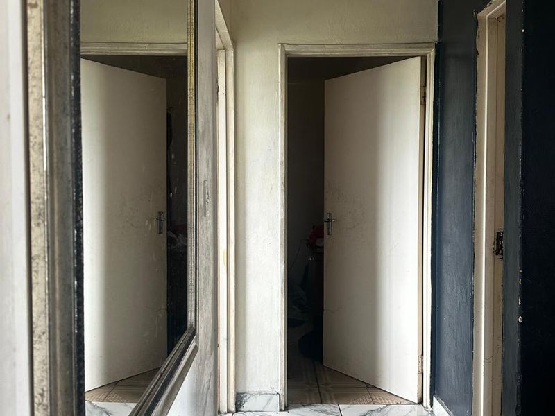 A functional hallway featuring tiled flooring and multiple internal doorways, providing access to various rooms within the home.