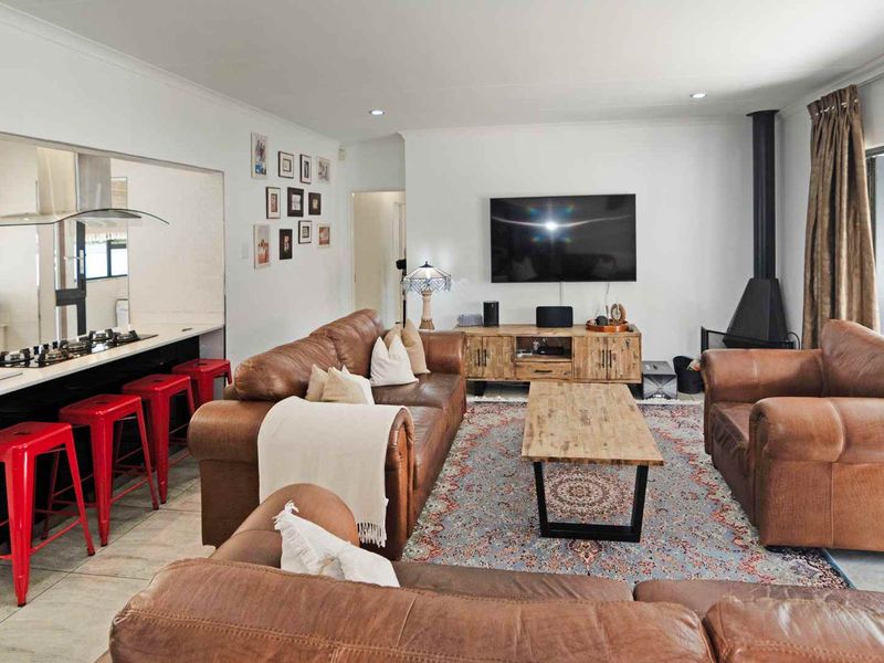 Open-plan living area featuring a modern kitchen with a gas hob, tiled flooring, and a cozy fireplace, creating a functional and inviting space.