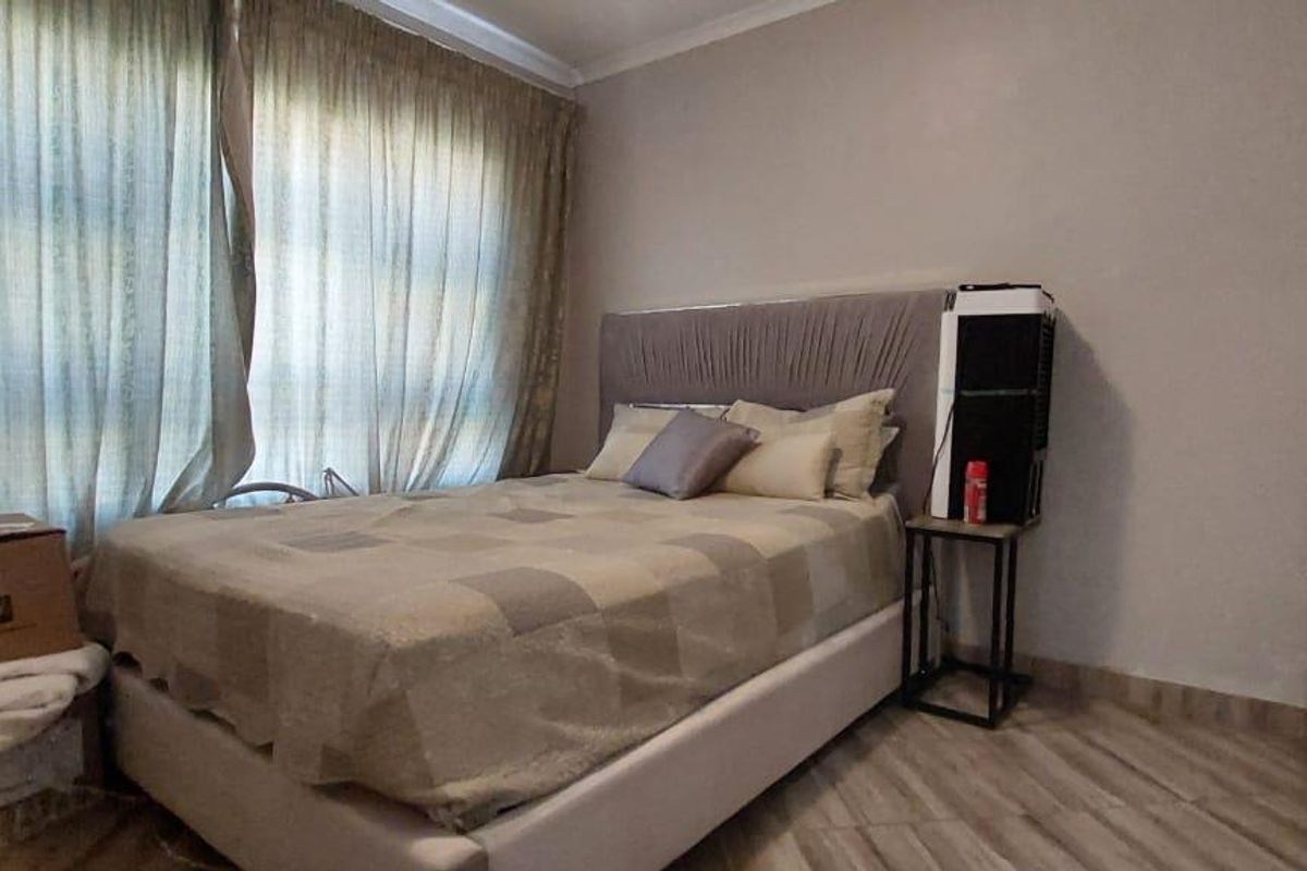 A bedroom featuring built-in cupboards and tiled flooring, providing a functional living space.
