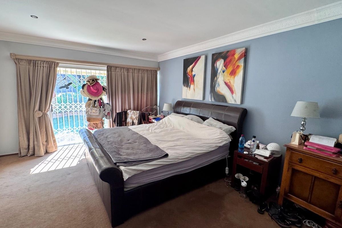 Spacious bedroom featuring built-in cupboards, crown molding, and sliding glass doors providing direct access to the outdoor area.