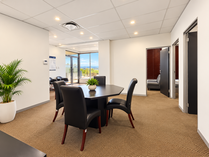 A well-maintained office space featuring a suspended ceiling, recessed lighting, carpeted flooring, and access to an outdoor balcony area.