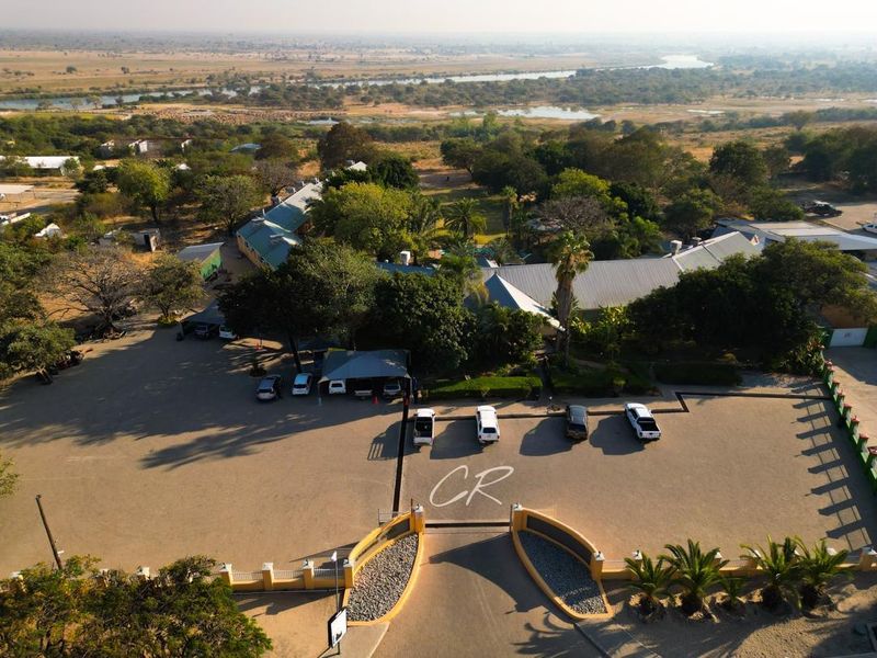 Aerial view of the hotel property featuring extensive parking facilities, landscaped grounds, and surrounding natural landscape.