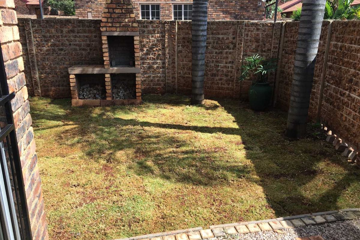 Private rear garden featuring a built-in brick braai, perimeter brick walling, and a lawn area.