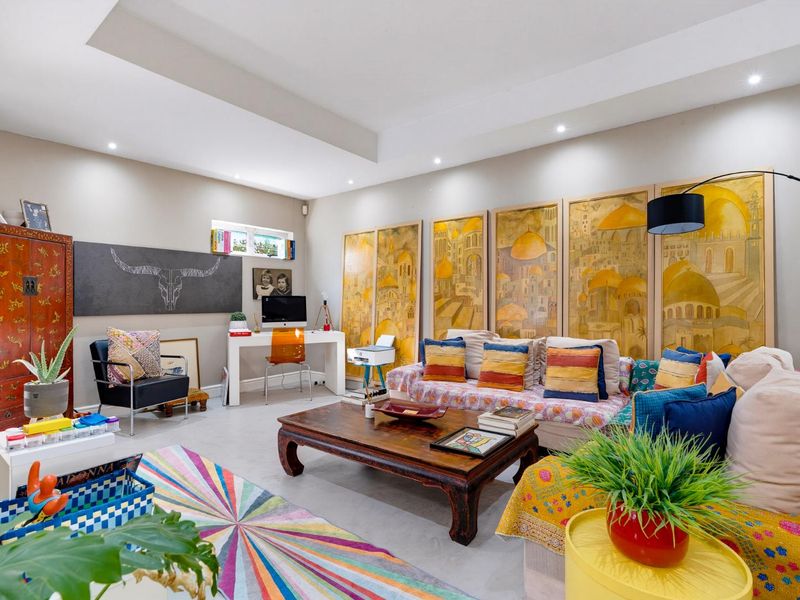 Spacious living room featuring a tray ceiling, recessed downlighting, and neutral tiled flooring, offering a bright and versatile living space.