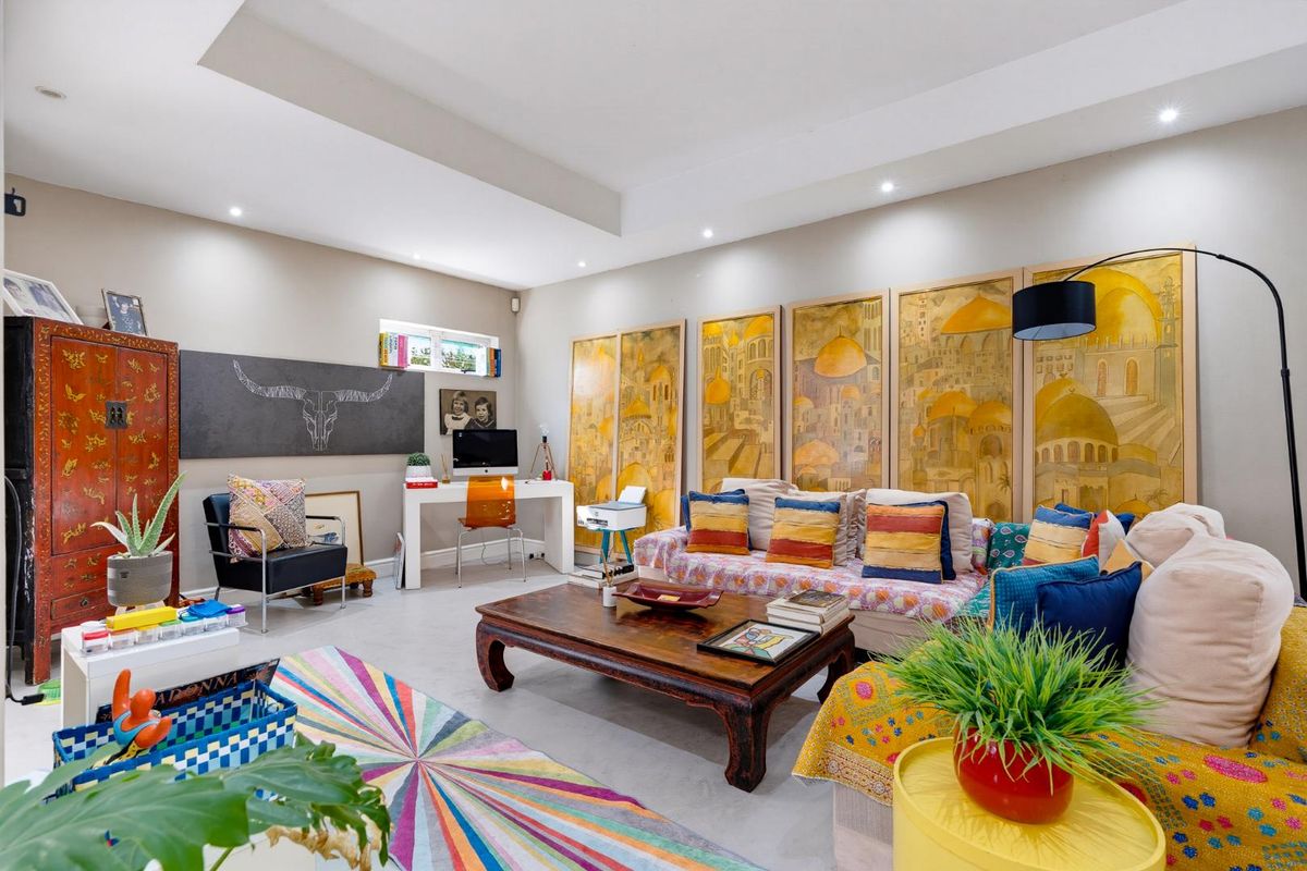Spacious living room featuring a tray ceiling, recessed downlighting, and neutral tiled flooring, offering a bright and versatile living space.