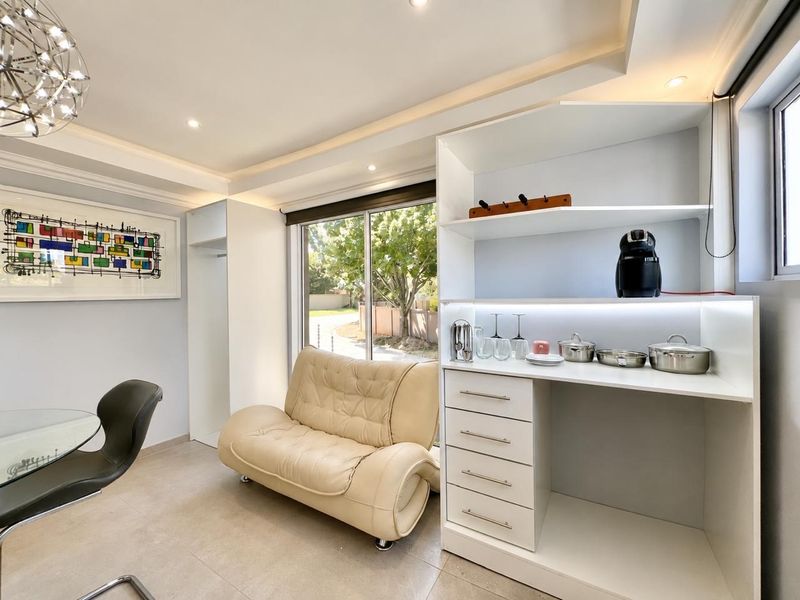 A bright living area featuring modern built-in cabinetry, recessed ceiling lighting, and large sliding glass doors that provide ample natural light.
