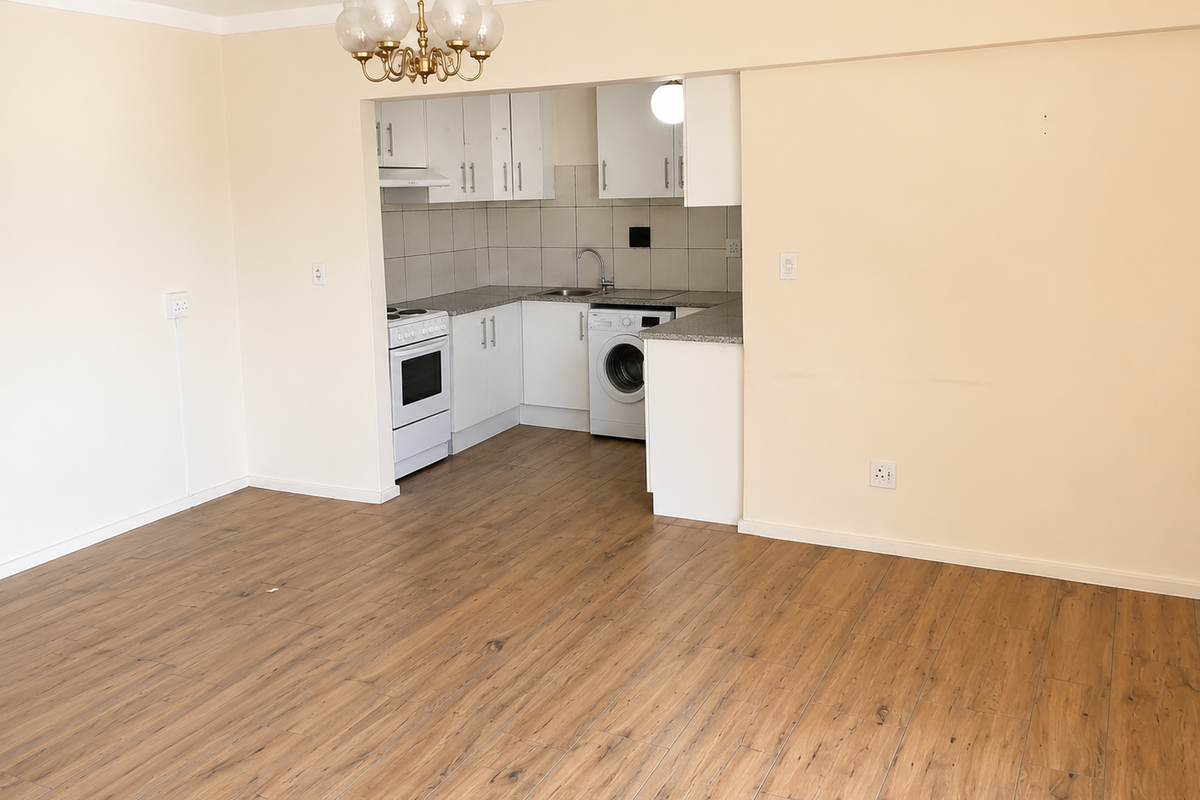 Spacious open-plan living area featuring modern laminate flooring and a compact, functional kitchen with built-in cabinetry and granite countertops.