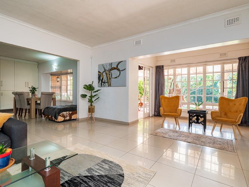 Spacious open-plan living and dining area featuring large windows, tiled flooring, and seamless flow to the outdoor patio area.