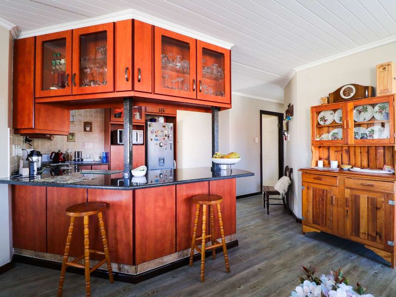 A kitchen featuring warm-toned wooden cabinetry, granite countertops, a breakfast bar, and a tongue and groove ceiling, offering a functional and traditional layout.