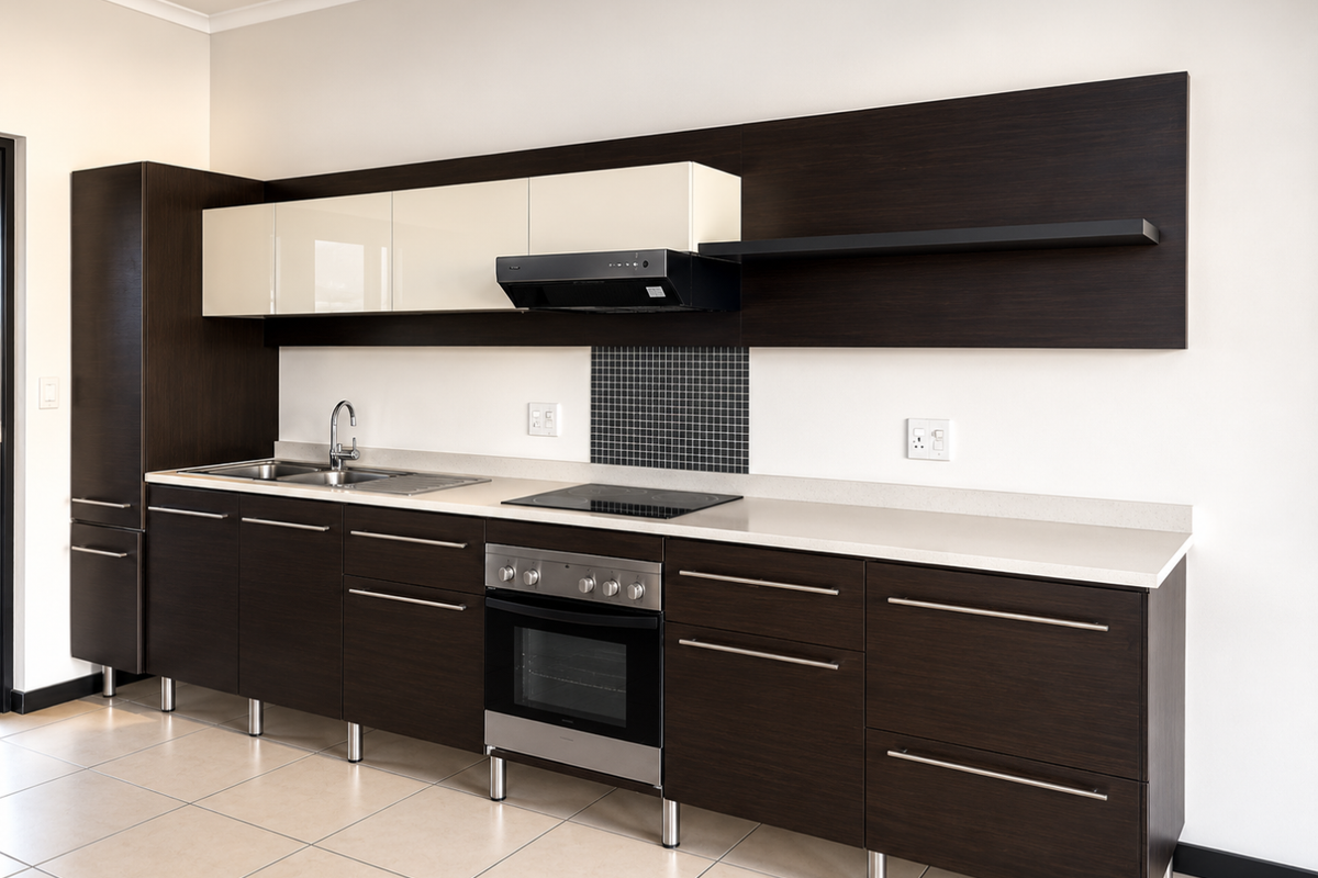 Modern kitchen featuring dark wood cabinetry, contrasting cream upper cabinets, stone countertops, integrated stainless steel appliances, and a mosaic tile splashback.