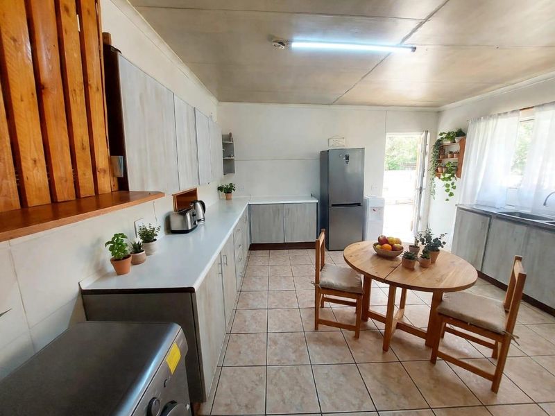 A functional kitchen featuring built-in cabinetry, laminate countertops, and ceramic floor tiles, with direct access to the exterior.