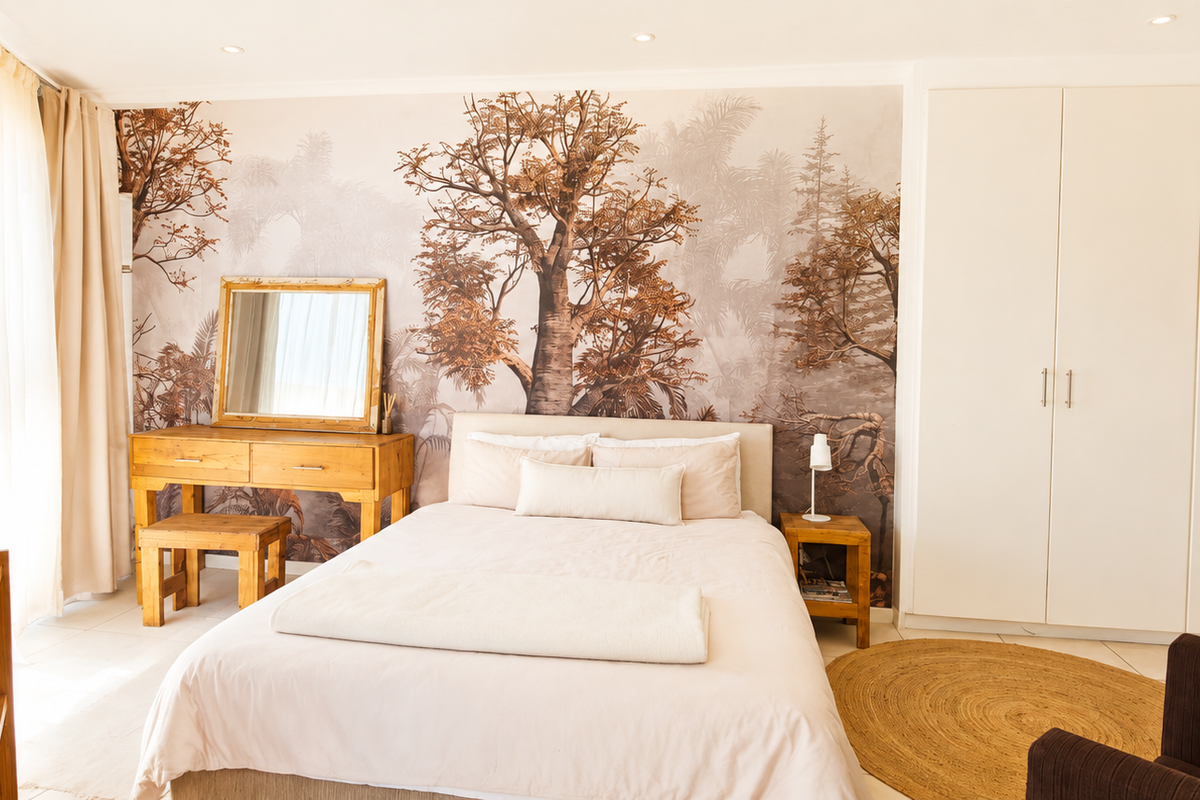 A well-lit bedroom featuring built-in cupboards, neutral tiled flooring, and a decorative feature wall, creating a warm and inviting atmosphere.