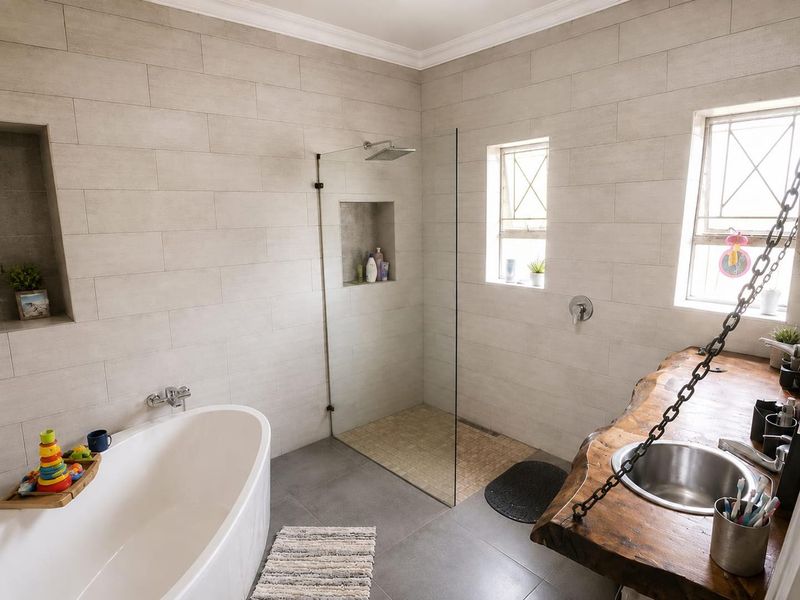 Modern bathroom featuring a freestanding bathtub, walk-in shower with glass screen, and a unique live edge wood vanity with an undermount sink.