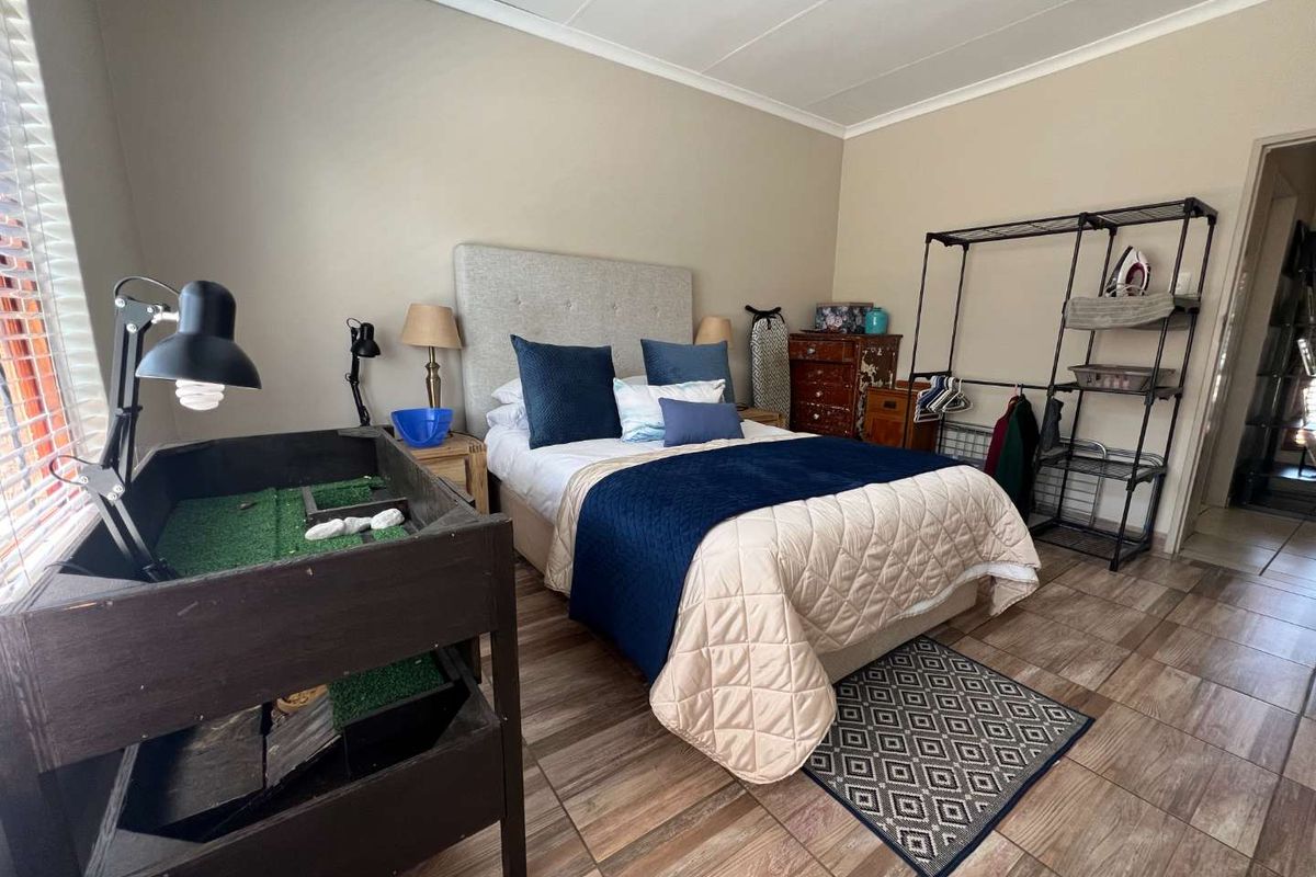 A well-lit bedroom featuring tiled flooring, neutral wall tones, and a standard ceiling, providing a functional and comfortable living space.