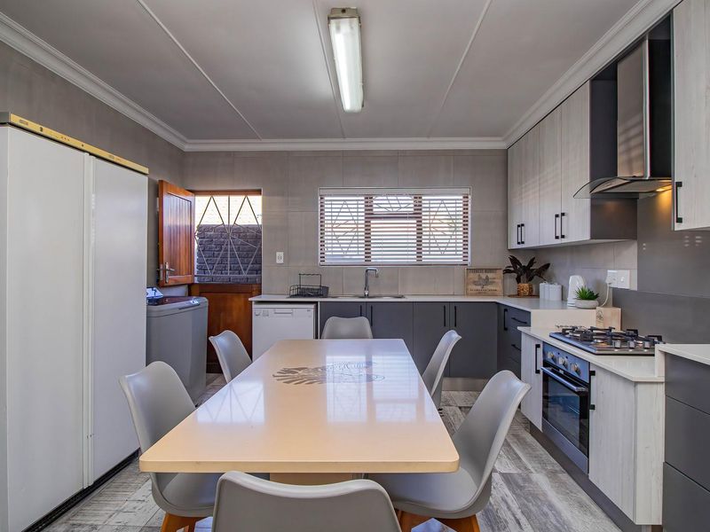 Modern kitchen featuring sleek cabinetry, gas hob, integrated oven, extractor fan, and tiled backsplash, offering a functional and contemporary cooking space.