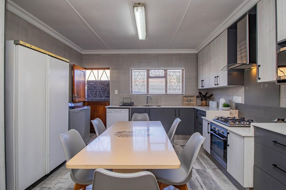 Modern kitchen featuring sleek cabinetry, gas hob, integrated oven, extractor fan, and tiled backsplash, offering a functional and contemporary cooking space.