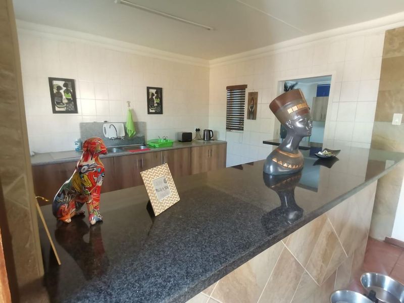 A functional kitchen featuring granite countertops, a breakfast bar, and tiled backsplash, offering a practical layout with ample workspace and storage cabinetry.