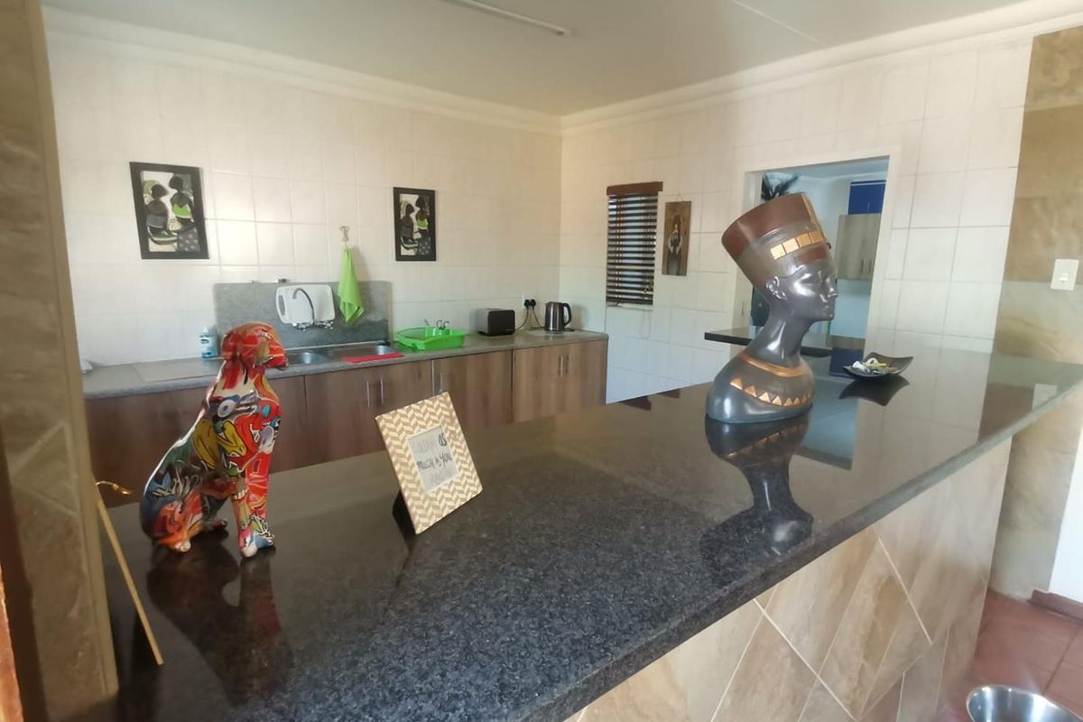 A functional kitchen featuring granite countertops, a breakfast bar, and tiled backsplash, offering a practical layout with ample workspace and storage cabinetry.