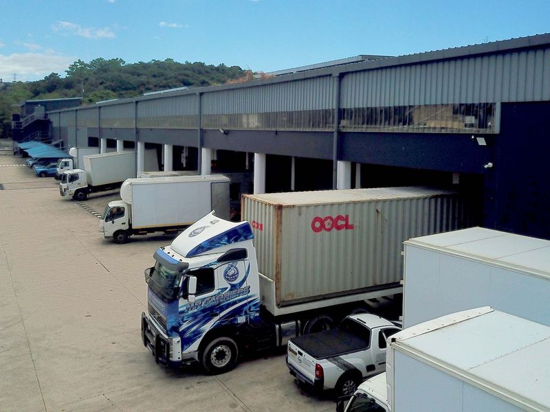 Industrial warehouse exterior featuring multiple loading bays, concrete yard space, and metal cladding, suitable for logistics and distribution operations.