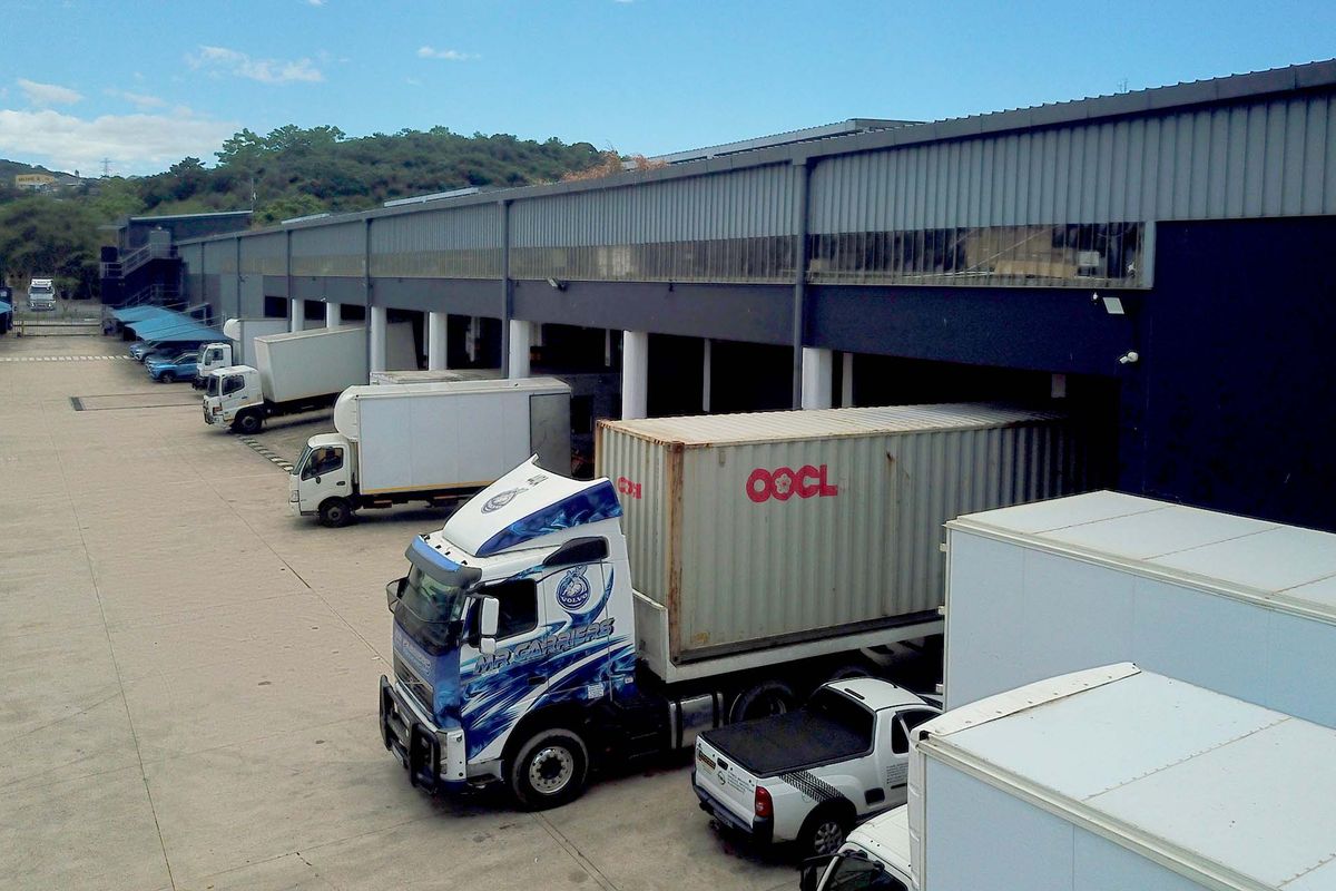 Industrial warehouse exterior featuring multiple loading bays, concrete yard space, and metal cladding, suitable for logistics and distribution operations.